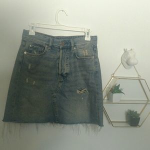 Distressed denim skirt with raw hem and button fly